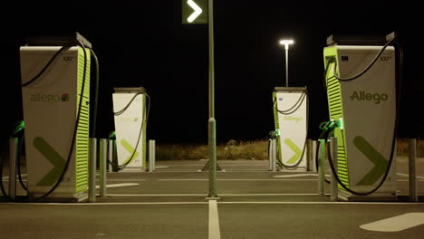 deserted allego european ev charging stations at night time, zoom out