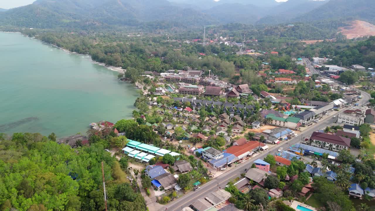 aerial drone footage of Koh Chang island, Klong Prao with main road, shops, mountains and ocean