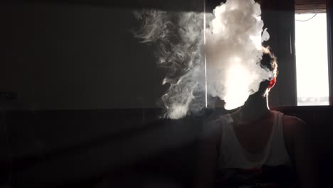 hombre vapeando en la oscuridad de una habitación