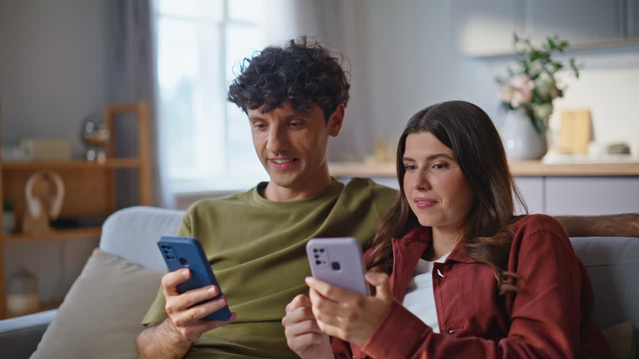 Amazed winners watching smartphones reacting success at room together closeup