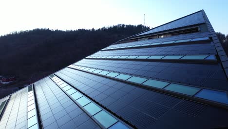 solar panels on roof of office building powerhouse in porsgrunn telemark norway - slow evening aerial showing rooftop of modern building producing more electricity than it consumes