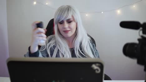bloguera de video está revisando cosméticos frente a una cámara profesional