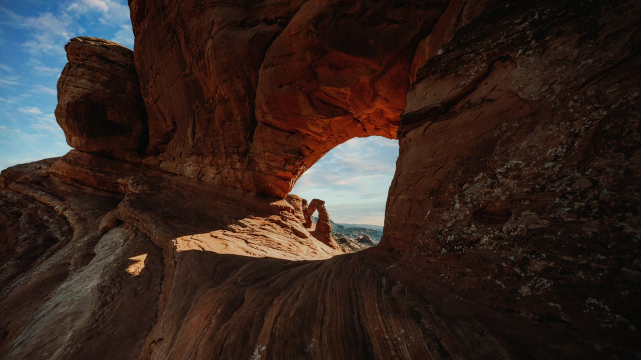 Time lapse del Delicate Arch incorniciato da un cielo nuvoloso. Paesaggio dell'Arches National Park, Utah, USA. Video in loop