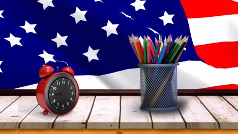 american flag with alarm clock and pencils