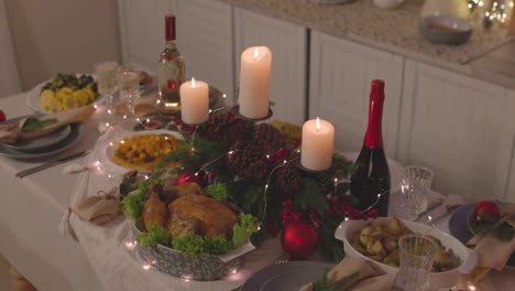 deliciosa comida tradicional y velas encendidas en la mesa de la cena de navidad 3