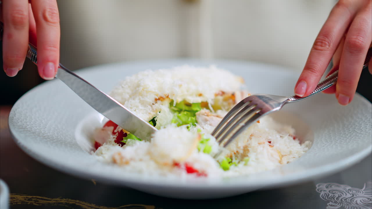 Woman eating Caesar salad at a restaurant