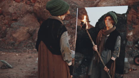 woman with torch looking in mirror in dystopian world