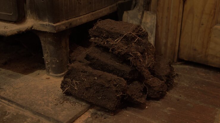 Small stack of dried turf beside stove
