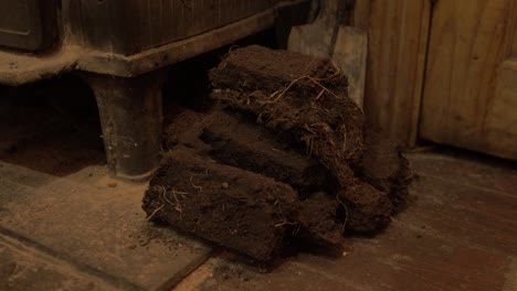 small stack of dried turf beside stove