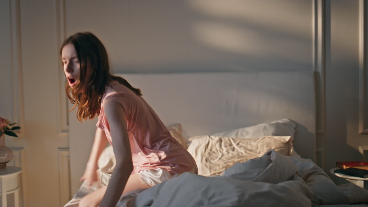 늦은 잠을 자던 소녀는 아침에 침실을 서두르며 늦은 시간에 드폰으로 얘기하는 여자