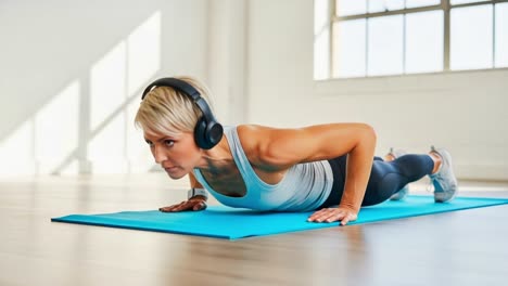 focused fitness: a determined individual engaging in push-up exercises while wearing headphones in a bright, spacious workout environment