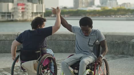 happy couple holding hands and spinning on wheelchairs