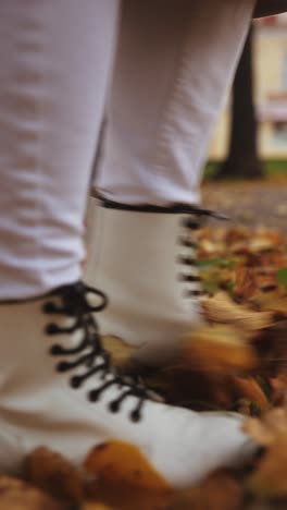 mujer caminando por las hojas de otoño