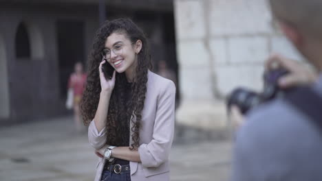 woman talking on phone, being photographed on the street