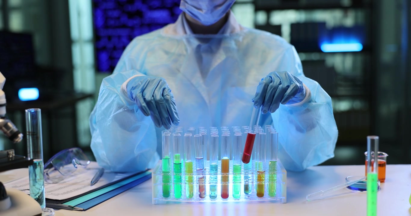Un tecnico di laboratorio esamina provette piene di liquidi colorati