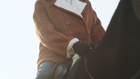 mujer de primer plano montando a caballo en la granja