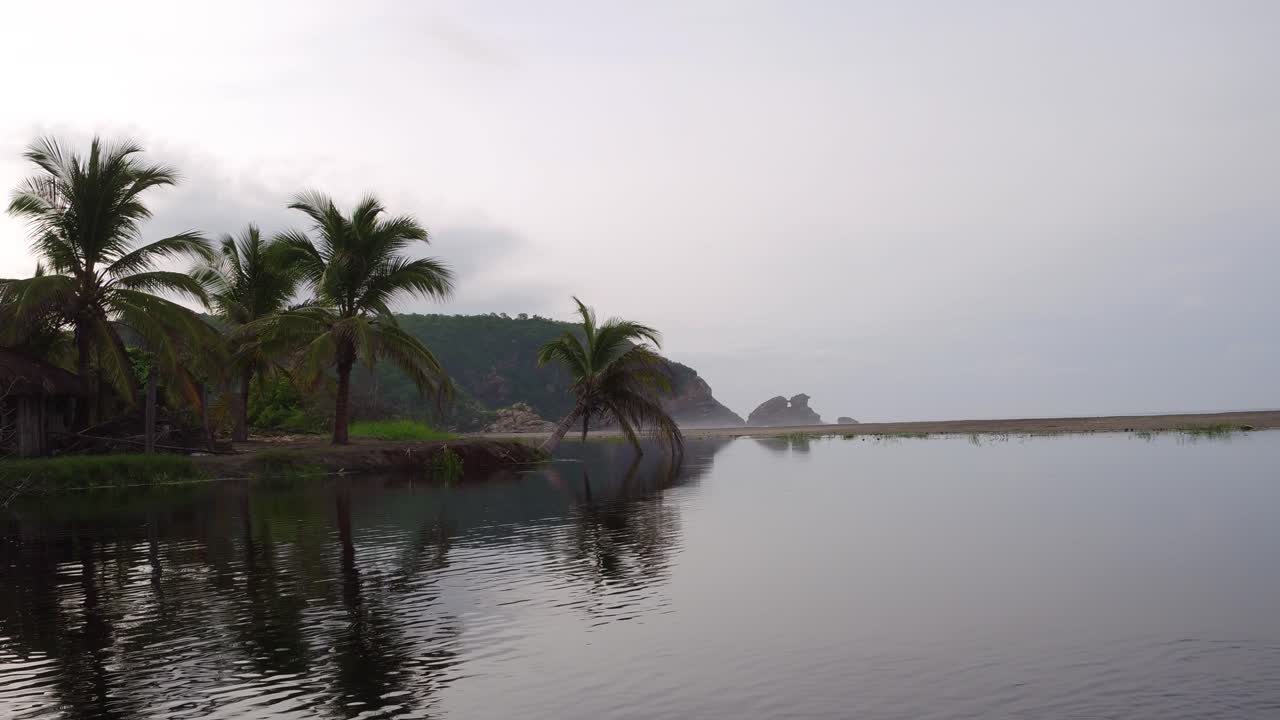 Shot of the lagoon and a rock formation at the back with waves braking