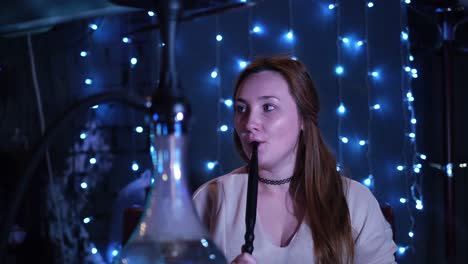 woman enjoying a hookah in a night club