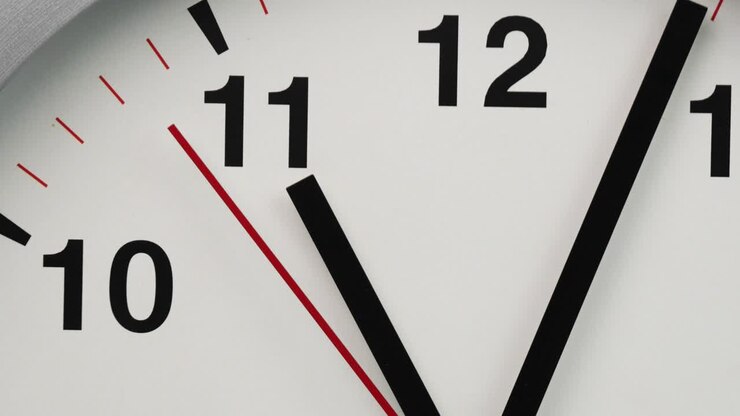 Close-up white wall clock show the time at 11o'clock.