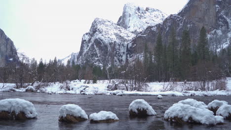 plano general, el velo nupcial de yosemite cae en la nieve con el río merced en primer plano