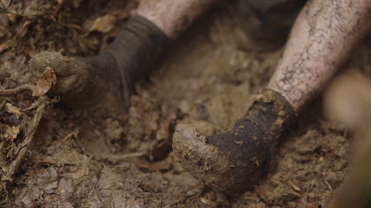 Moody close-up of feet in black socks during an intense interrogation moment