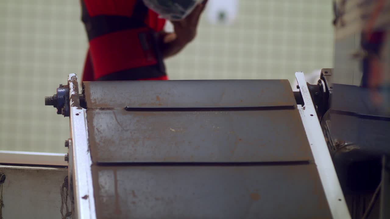 descarga de paquetes de granos de café empaquetados de la cinta transportadora en la línea de montaje de la fábrica