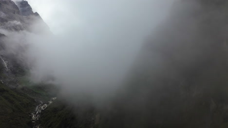 un dron aéreo disparó a través de un clima brumoso hacia las montañas de annapurna, nepal