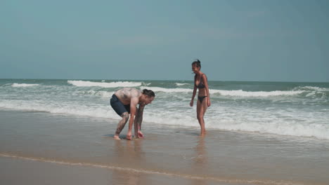 pareja jugando en la orilla