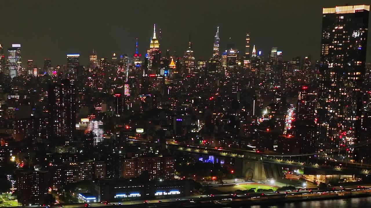 Nighttime aerial view of New York City skyline with bright lights