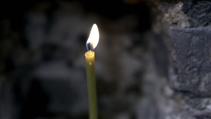 Luce di candela su un muro di mattoni