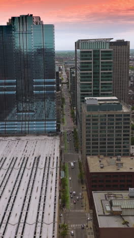 rows of beautiful modern buildings of stunning chicago, illinois. drone footage over subway depot. pink sky at backdrop. vertical video