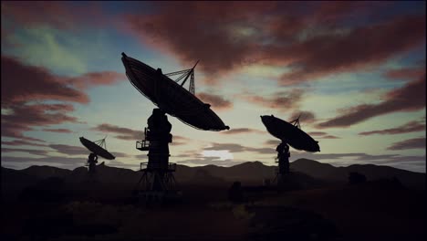 satellite dishes on field against cloudy sky during sunset