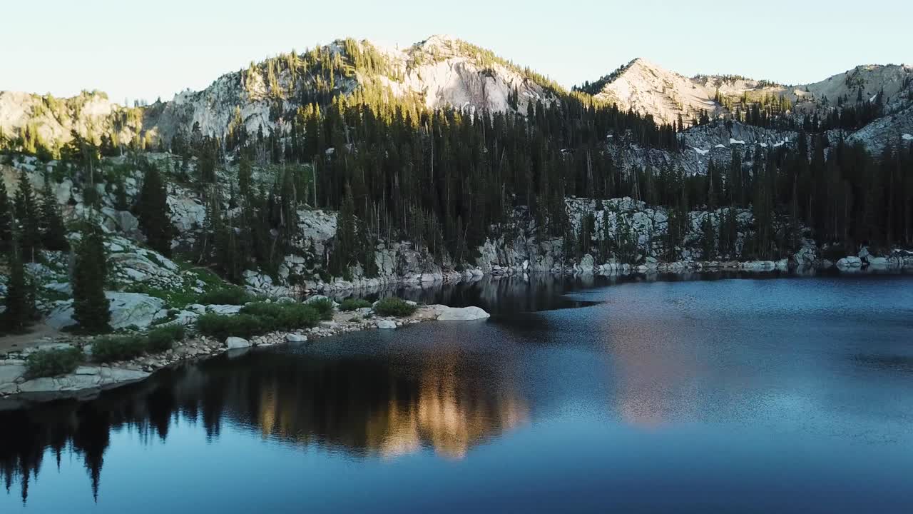 Ripresa con drone che plana dolcemente sopra un lago in alta quota nelle montagne dello Utah.