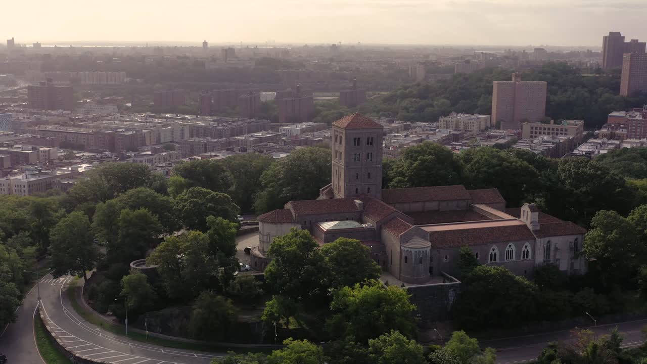 rápida elevación de la órbita aérea en sentido contrario a las agujas del reloj sobre los claustros en el alto manhattan nyc en brumoso sol matutino