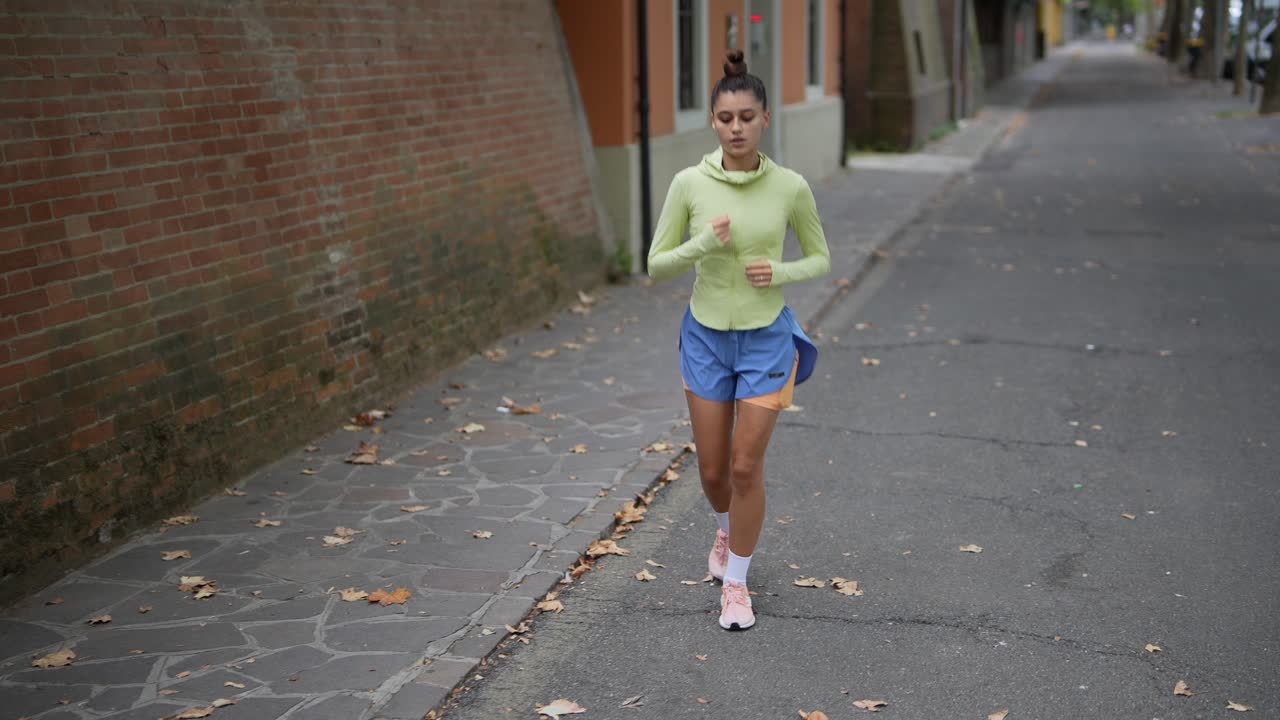 mujer corriendo por la calle de la ciudad
