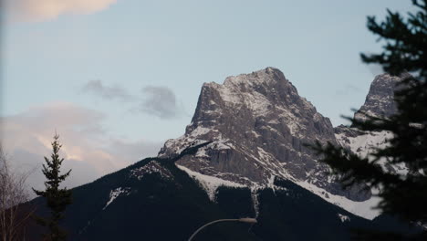time-lapse of clouds rolling behind a mountain peak