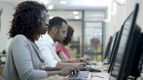 students passing exams by computers in class