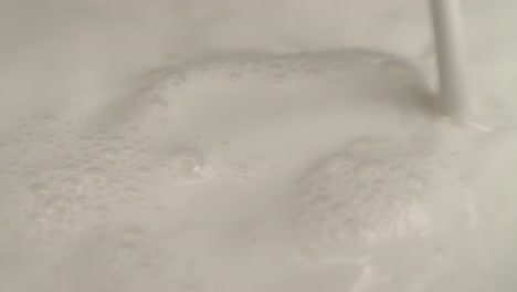 close-up of pouring milk into a black pot for making cakes and desserts