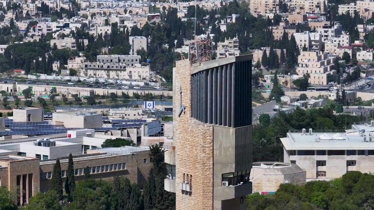 Detaljeret tele-droneudsigt, der fremhæver toppen af Det Hebraiske Universitets observationstårn på Mount Scopus med Jerusalems bybakker i baggrunden