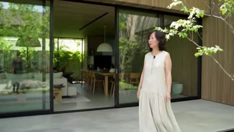 a serene encounter with nature: a woman strolling through a stylish modern home surrounded by lush greenery and elegant design elements