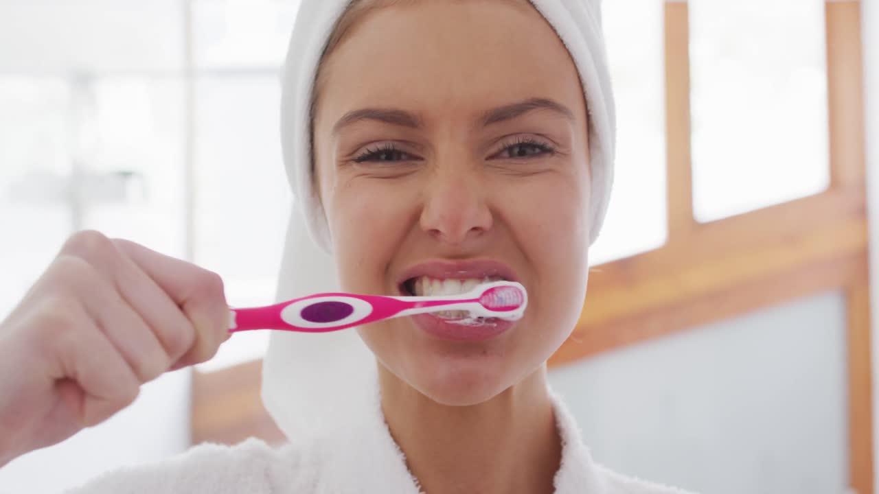 retrato de una mujer en albornoz cepillándose los dientes