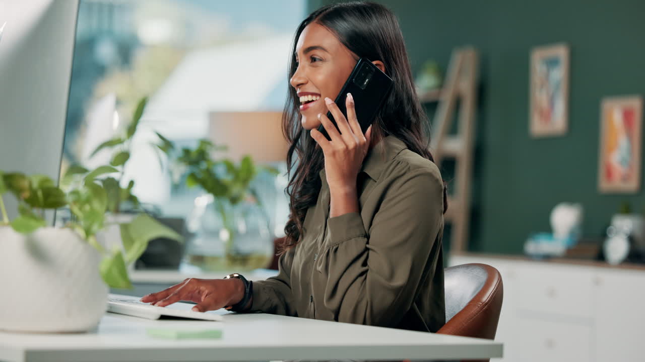 A woman working in her home office and talking on her phone