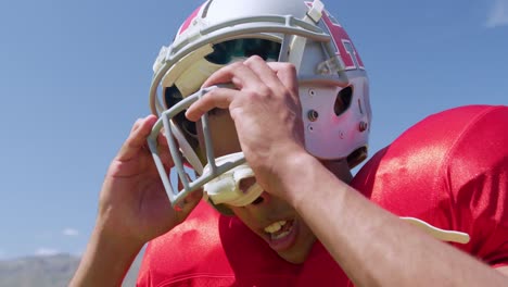 american football player removing helmet