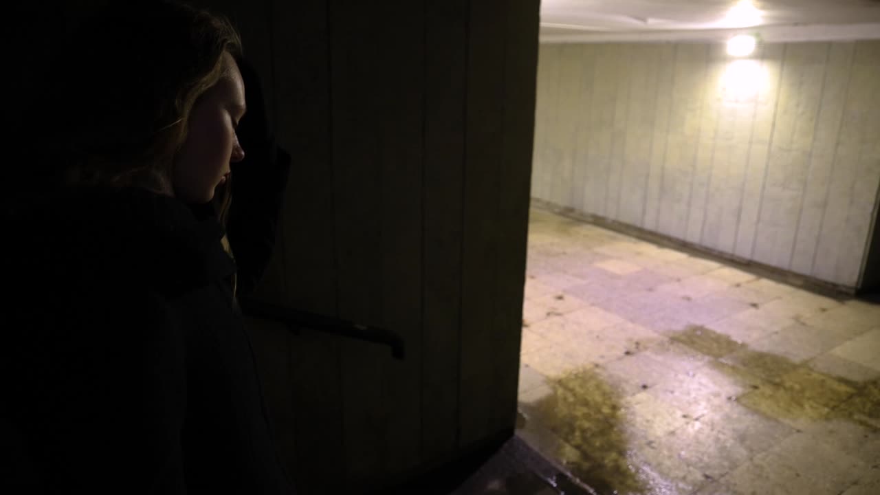 Girl walking down to the underground passage at night time