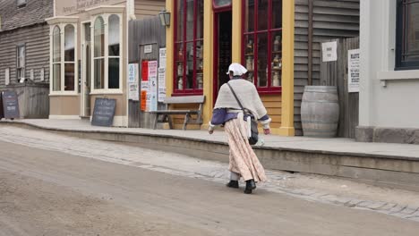 woman in period attire walking down street