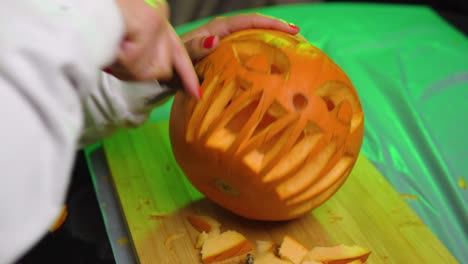 tallado de dientes en la boca en el interior de la calabaza con luz verde