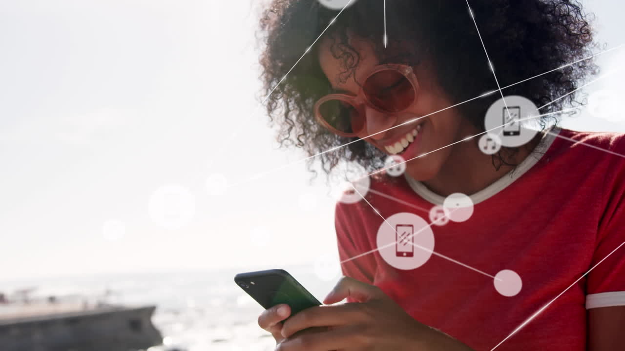 Animation of network of connections over woman using phone on the beach