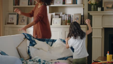 cute-little-girl-playing-catch-with-parents-at-home-mother-and-father-having-fun-running-after-child-at-home-enjoying-family-time-on-weekend