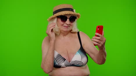blogger viajera mujer madura con gafas de sol, tomando una foto de retrato selfie, llamada de video en teléfono inteligente