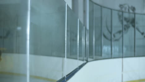 young male hockey player sliding fast and falling after a collision with another player on the ice arena